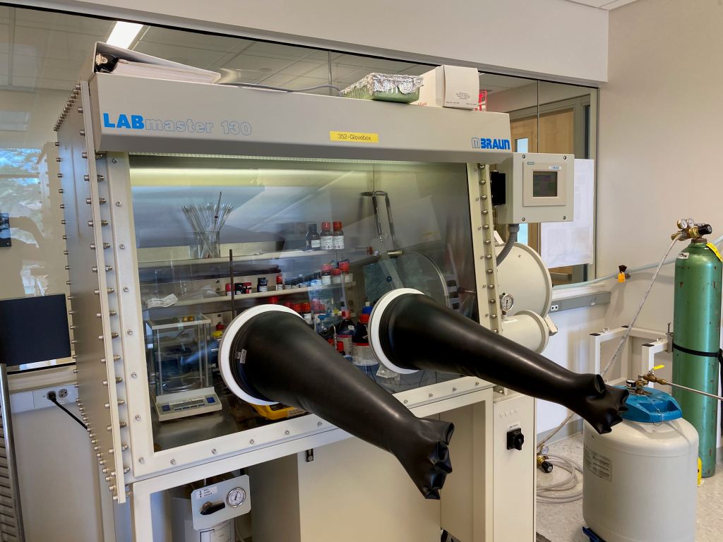 The image shows a glove box, which allows our group to do chemical reactions under a dry and inert nitrogen atmosphere.